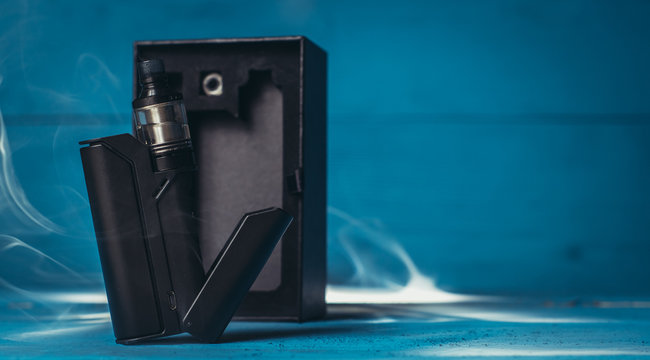 vaporizer with a black box on a blue background with white smoke