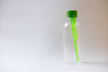 plastic bottle of water green straws inside