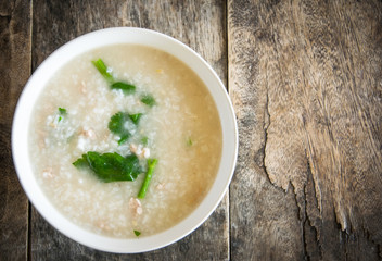 Thai style of rice gruel in bowl on wood background