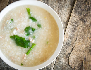 Thai style of rice gruel in bowl on wood background