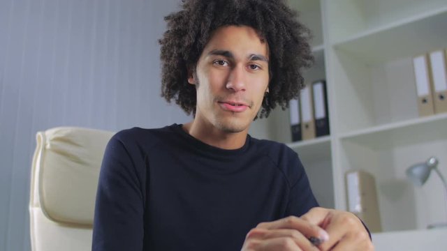 The guy holds the pen in hand and communicates with the client