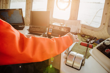 Man fishing vessel captain in the ship's wheelhouse. The control system, navigation system. Fishing, industry, fishery. © scharfsinn86