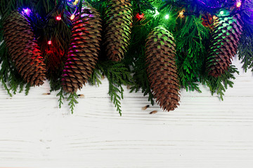 christmas garland lights and pine cones on fir branches. stylish