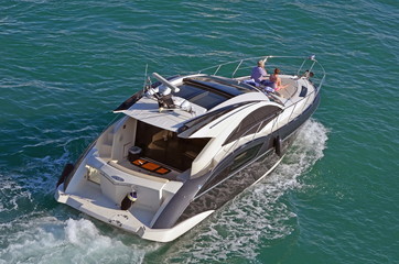 Couple enjoying a Saturday afternoon cruise on the Florida Intra-coastal waterway from the forward deck of an upscale cabin cruiser.