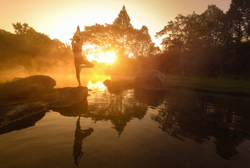 Asian Young woman doing yoga in morning park,Woman Yoga relax in nature,Asian woman is practicing yoga at mountain lake