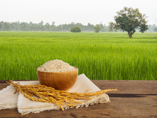 Jasmine rice in bowl and gloden spike on wooden table of morning