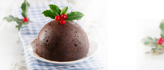 Christmas pudding with holly on a white plate.
