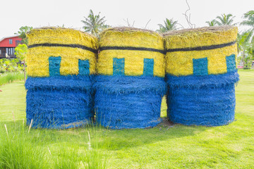 Straw bales, yellow, blue, in a park in Thailand.