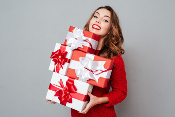 Woman in red sweater holding many boxes
