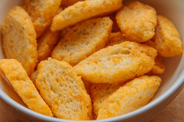 Close-up of toasts with olive oil in a white bowl on wooden boar