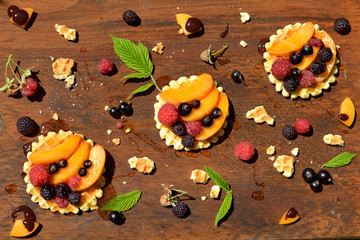 Waffles, honey, peach, currant, strawberry on wooden table