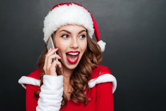 Woman in santa claus costume talking on the cell phone