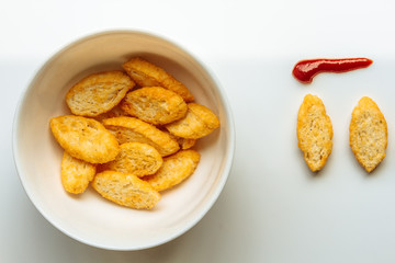 Row of toasts next to white bowl full of toast with olive oil an