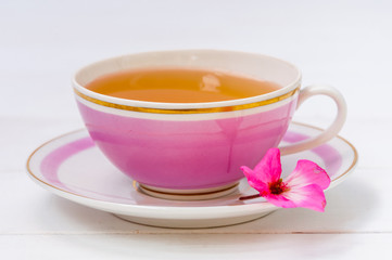 Pink cup of tea on white background