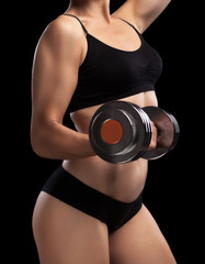 Fototapeta premium Athletic girl with dumbbells in hand.