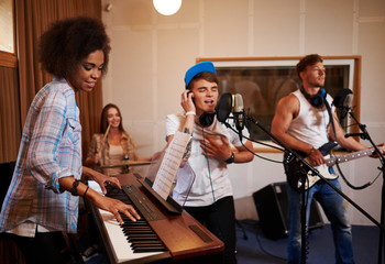Fototapeta na wymiar Multiracial music band performing in a recording studio