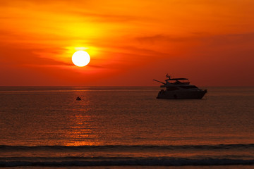 Silhouette boat and sunset over the sea.