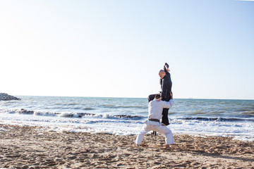 karate sparing on the beach sand sea background