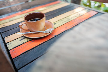 A cup of coffee on a wooden table.