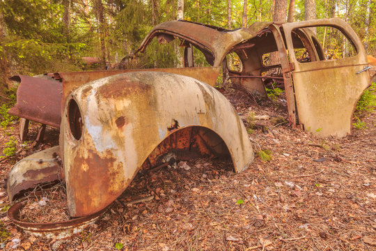 Old rusted scrap car in a forest