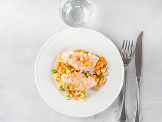 Steamed salmon with carrots and sesame. Top view