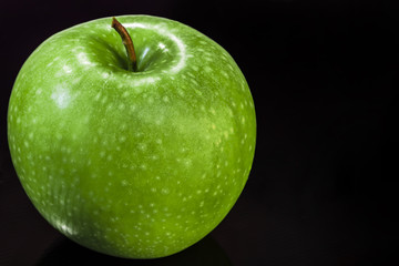 Close-up of green apple on a black background
