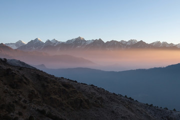 Misty mountain sunrise landscape in Himalayas, Nepal. Misty mountains scenery with high altitude peaks and Everest mountain on the background.
