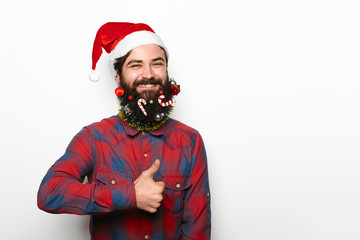 happy man with beard and christmas decorations showing thumb up