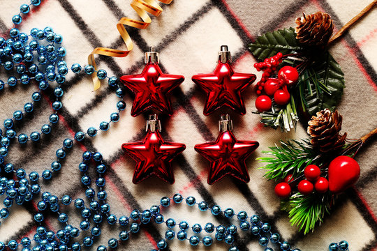 Unusual Christmas ornaments beautifully decorated, lying on warm plaid.