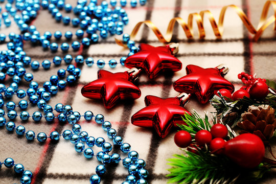 Unusual Christmas ornaments beautifully decorated, lying on warm plaid.