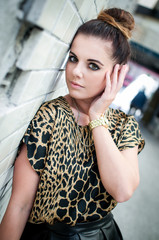 Portrait of a beautiful glamorous brunette wearing black short skirt and panther shirt with golden...