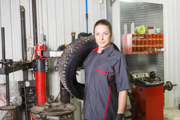 Fototapeta na wymiar Mechanic woman working on car in his shop