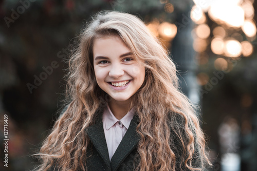 Smiling blonde teen girl 13-13 year old with curly hair wearing ...