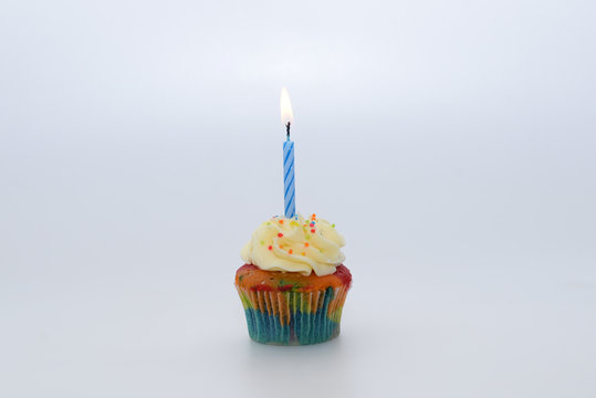 Cupcake with candle on white background