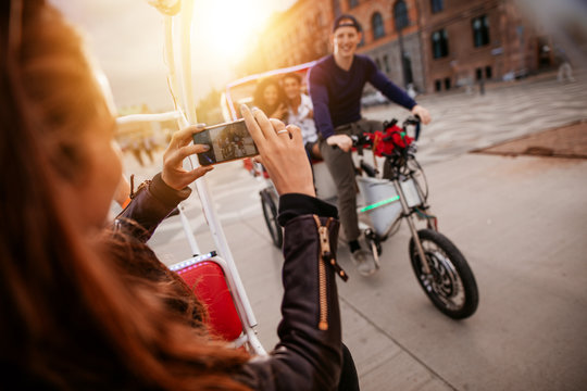 Woman taking picture of friends on tricycle