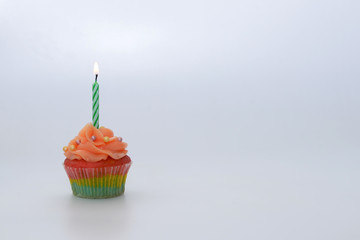 Cupcake with candle on white background