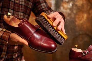 Man polishing leather shoes with brush.