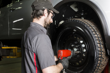 Mechanic working on car in his shop