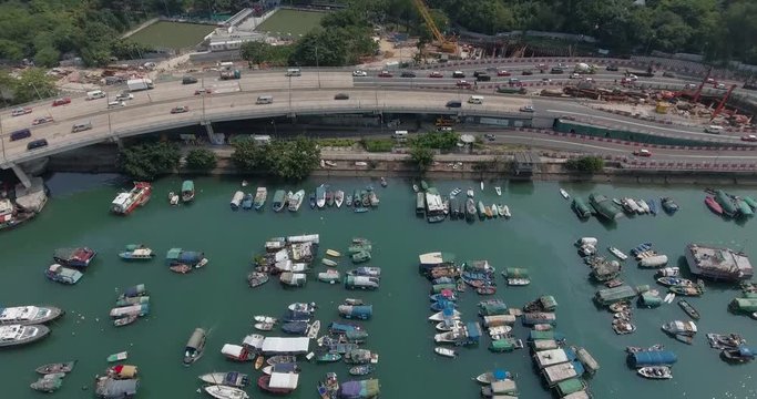 Aerial view of traffic intersection on a major freeway in the downtown of Hong Kong and boats in Victoria Harbor.