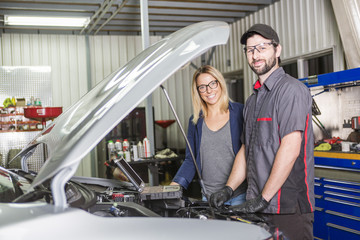 auto mechanic and female customer in garage