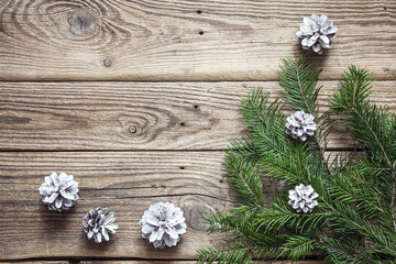 Fir branches with cones on old wooden boards. Christmas backgrou