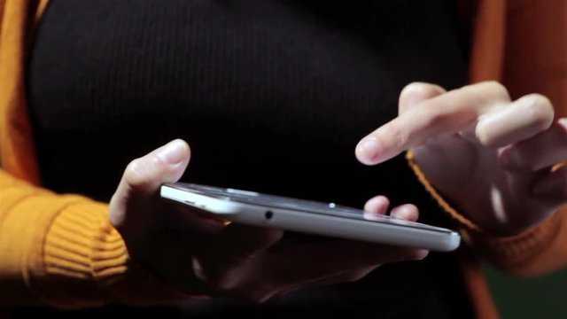 Footage of a person's hands using a tablet.