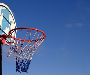 Basketball basket hoop and backboard isolated against blue sky