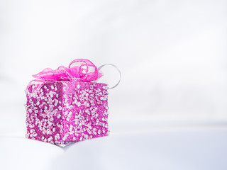 Pink gift box on gentle fabrics background