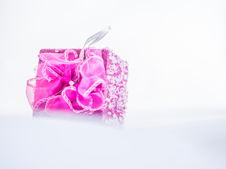 Pink gift box on gentle fabrics background