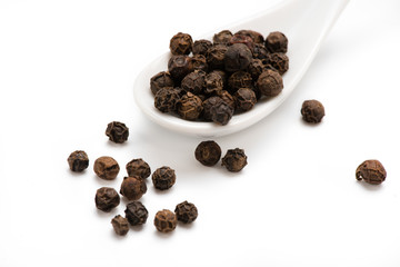 Black pepper in white spoon isolated. Spices. .