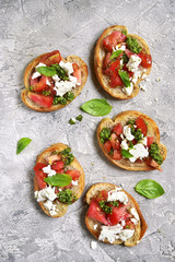 Italian bruschetta with tomatoes,feta and basil pesto.Top view.