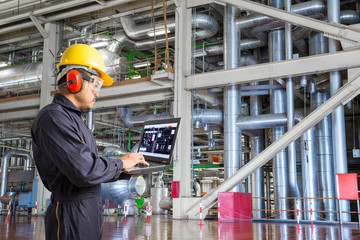 Engineer using laptop computer for maintenance in factory
