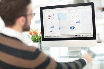 Handsome young man wearing glasses and working with modern compu