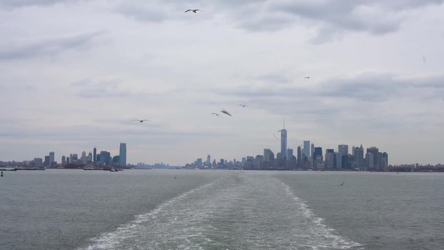 View of Manhattan from the Staten Island Ferry, with waves in the wake of the ferry across New York Harbor